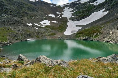 Dağın tepesindeki bir buzuldan oluşan mavi alp gölü. Altai Rusya
