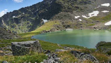 Dağın tepesindeki bir buzuldan oluşan mavi alp gölü. Altai Rusya