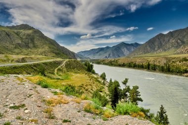 Dağ nehri boyunca dağlarda motorlu yol