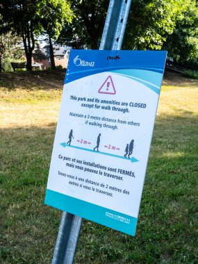 Strathcona Park 'taki bir Ottawa şehri tabelası COVID-19 salgını dışında parkın kapalı olduğunu gösteriyor ve fiziksel uzaklık talimatları veriyor..