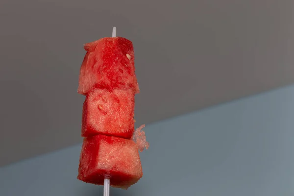Plastik bir şiş üç parça doğranmış karpuzla kaldırılır..