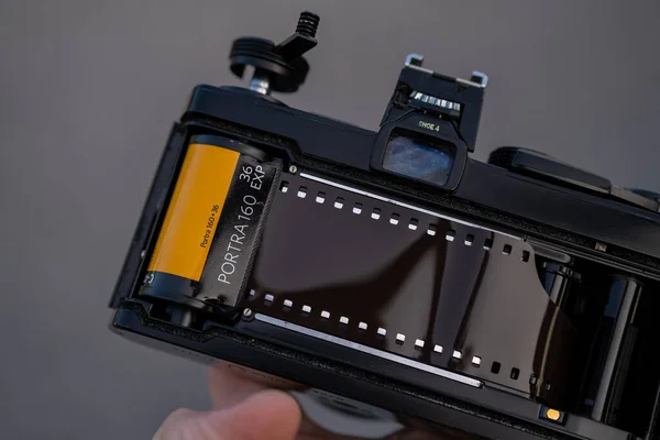 一只手拿着一个背开的模拟Slr相机 背面装有柯达Portra 160彩色胶卷 — 图库照片