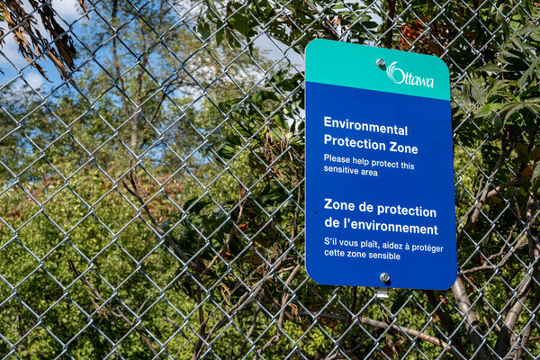 Город Оттава знак на цепи звено забора информирует посетителей Карлингтон-парк, что район является экологической зоной.