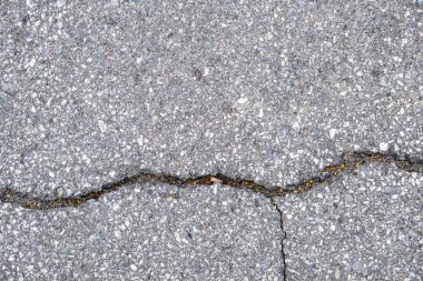 Yukarıdan asfaltla kaplanmış, içinden büyük bir çatlak geçen bir alan ve aşağıdan daha küçük bir dik çatlak görülür..