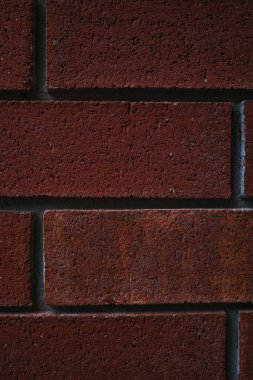 Duvardaki kırmızı tuğlaların portre yönelimli yakın plan görüntüsü desen ve detayı gösterir.