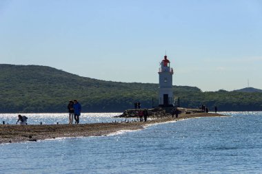 Vladivostok, Rusya - 18 Eylül 2019: Cape Egersheld'in ucunda bulunan Tokarevsky deniz fenerine giden istmus üzerinde turistler.