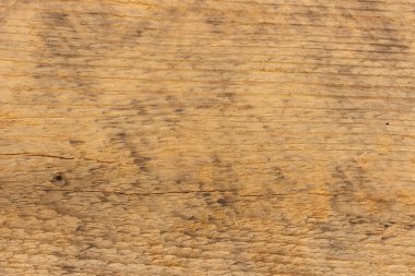 Eski bir tahtanın yüzeyi, güneşte yıpranmış ve solmuş.