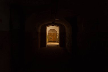 Karanlık bir yeraltı tünelinin çıkışındaki aydınlık kapı.