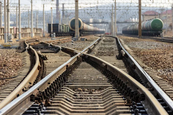 Rails, sleepers and trains with tanks at the railway freight station in Vladivostok, Russia.