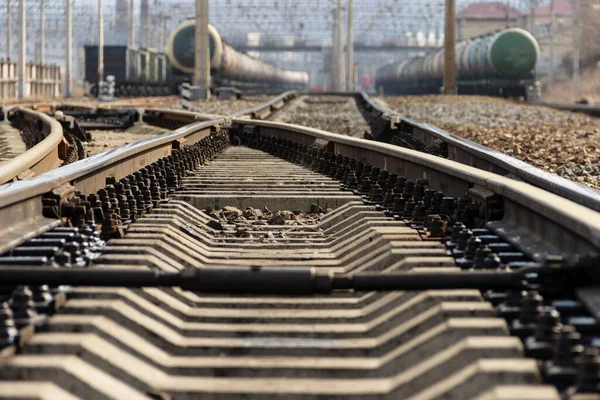 Rails, sleepers and trains with tanks at the railway freight station in Vladivostok, Russia.