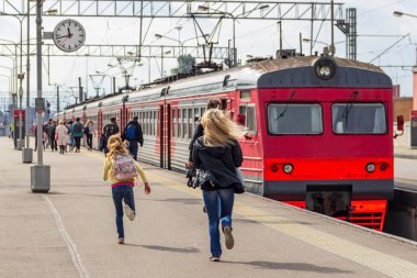 Tren peronunda koşan ve trene geç kalan yolcular (anne ve kız).