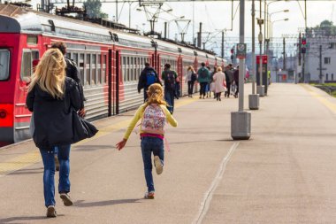 St. Petersburg, Rusya - Eylül, 05, 2020: Anne ve kızı tren peronunda koşuyorlar, aceleyle ve trene geç kalıyorlar.