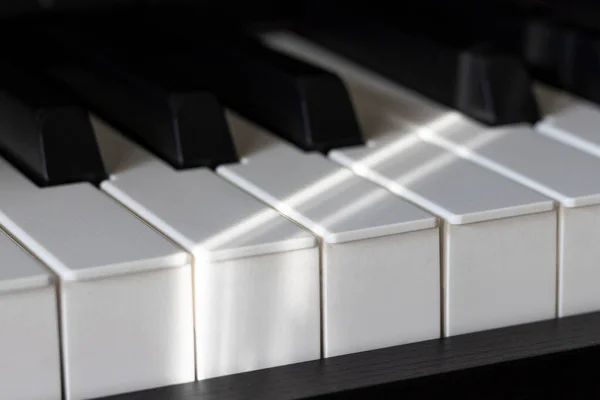 昏暗灯光和阴影下的黑白钢琴键 — 图库照片