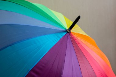 A multi-colored umbrella with stripes in rainbow colors (LGBT concept). clipart
