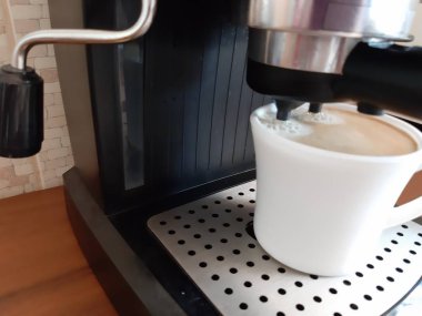 Fotoğrafta, bir kahve makinesiüzerinde kahve demleme işlemi.