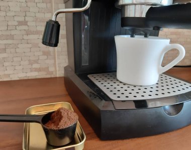 Fotoğrafta, bir kahve makinesiüzerinde kahve demleme işlemi.