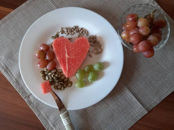 白い皿の上にベジタリアンのための食べ物です スイカ ブドウ ヒマワリの種とカボチャ — ストック写真