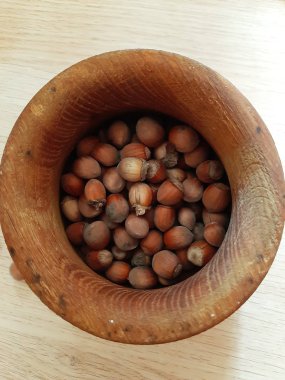 Fotoğrafta, el yapımı ahşap mutfak eşyaları ve fındık.