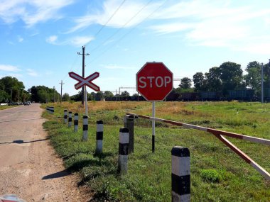 Yaz. Demiryolu geçişi, bariyer açık, yol açık.
