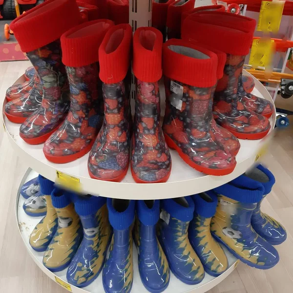 Autumn. Rainy weather. The shoe store has many colorful rubber boots.