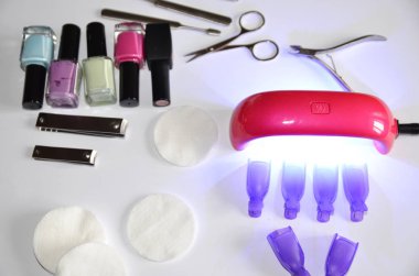 Evde manikür. Aksesuarlar: kurutma için lamba, jeller, araçlar, pamuk pedler.