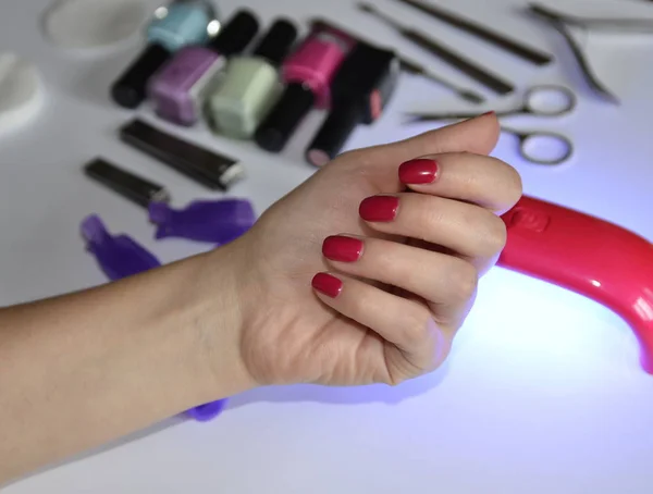 Manicure at home. Accessories: lamp for drying, gels, tools, cotton pads.