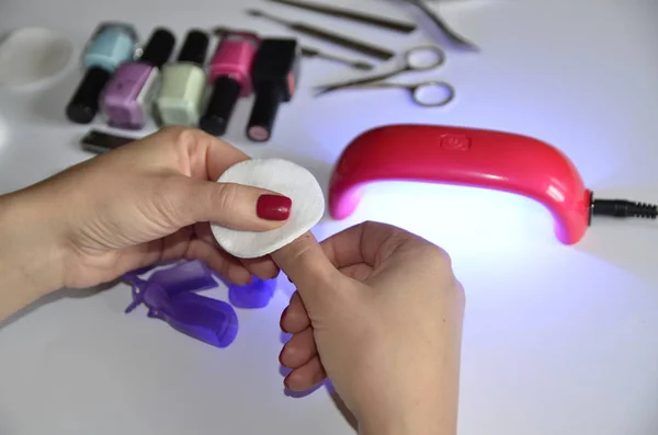 Manicure at home. Accessories: lamp for drying, gels, tools, cotton pads.