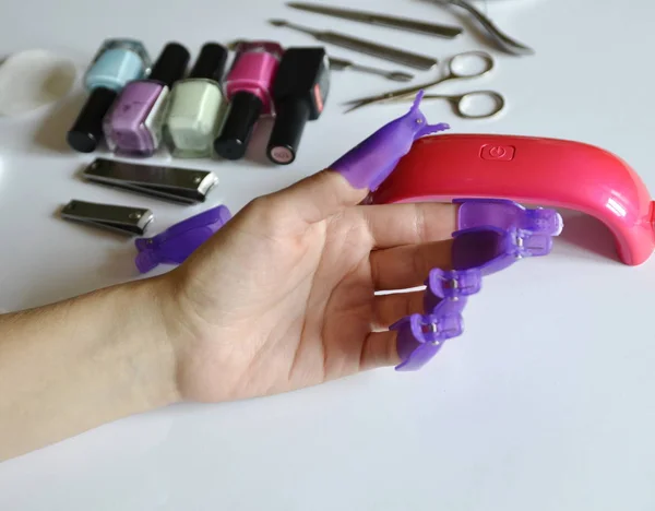 Manicure at home. Accessories: lamp for drying, gels, tools, cotton pads.