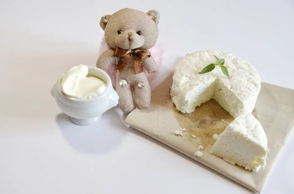 Healthy diet food. Dairy products. On the table is fresh delicious cottage cheese, sour cream and a toy teddy bear.