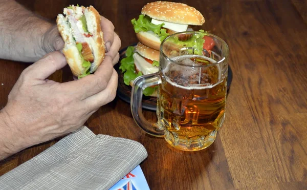 Man Drinks Beer Eats Delicious Burger — Stock Photo, Image