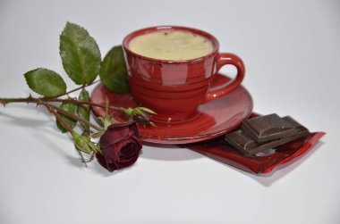 Sevgililer Günü. Bir fincan kahve, kırmızı gül, siyah çikolatalı tatlı..
