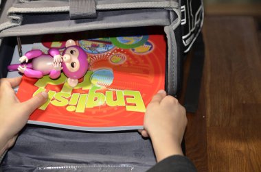 Fotoğrafta birinci sınıf öğrencisinin, okul kitaplarının ve oyuncakların açık portföyü var..