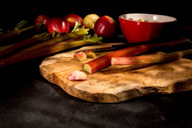 Taze ravent ve elmalar kesme tahtasında.