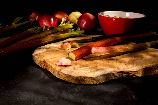 Taze ravent ve elmalar kesme tahtasında.