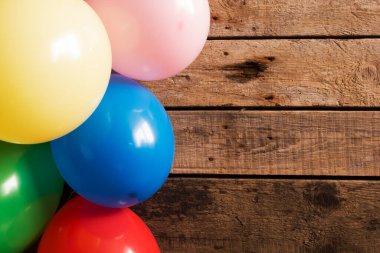 Ahşap arka planda renkli balonlar. Boşluğu kopyala. 