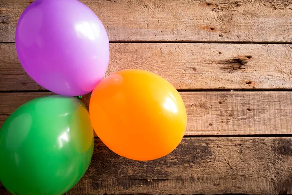 Ahşap arka planda renkli balonlar. Boşluğu kopyala. 