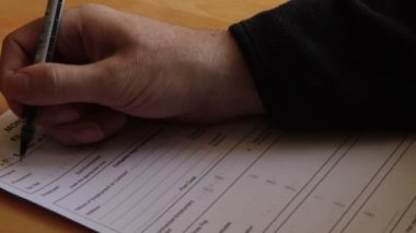Masa üzerinde bir form içinde kalem doldurma ile el