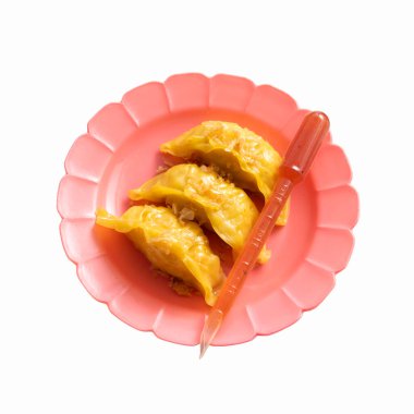 Tabakta Çin usulü hamur köftesi arka planda izole edilmiş, tabakta gyoza var.