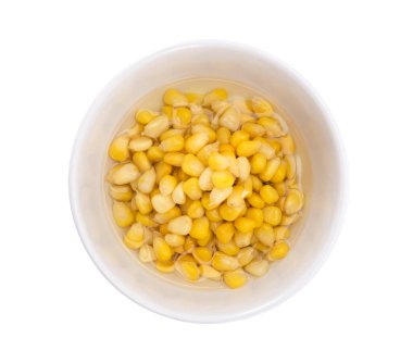 Bir kase mısır tohumu beyaz suda izole edilmiş.