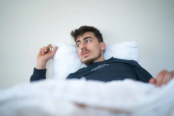 Man thinking in bed