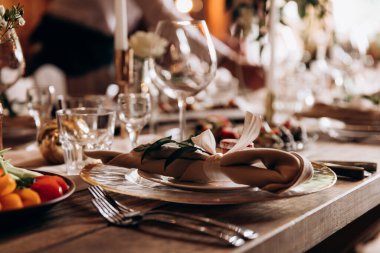 Lüks beyaz tabaklarla, parlak çatal bıçaklarla ve peçetelerle düğün masası düzenlemesi. Dekorasyonun zarif ayrıntıları. Zarafet ve hizmet kavramı.