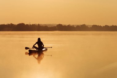 Kas sporcusu suda süzülmek için raket kullanıyor.