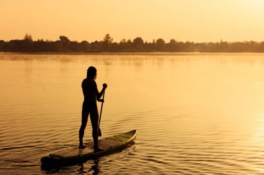 Yemek masasında yüzen genç bir adamın arka görünüşü.