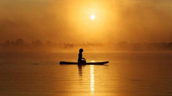 Man zitten op sup board en genieten van prachtige zonsopgang — Stockfoto