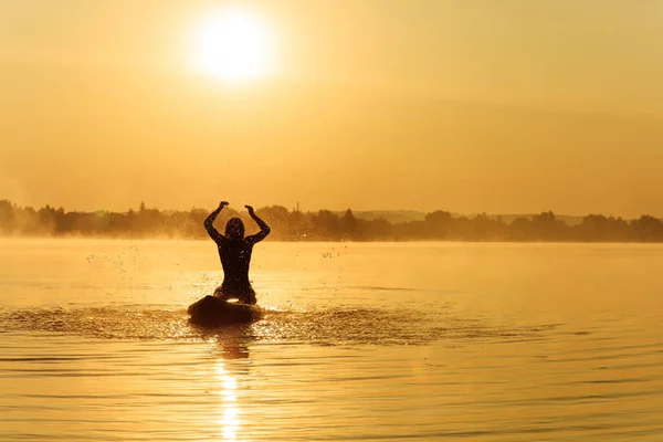 Kürek tahtasında sörf yapan ve su sıçratan mutlu adam. — Stok fotoğraf