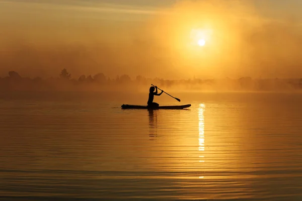 Sportsman em silhueta roaming a bordo durante o nascer do sol — Fotografia de Stock