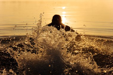 Gölde yüzen erkek sporcunun arkadan görünüşü