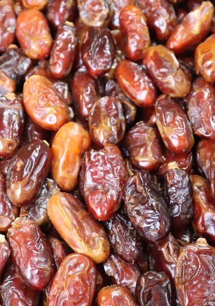 Meyve arkaplanlarıyla çıkıyor. Bir dükkanda hurma yığını.