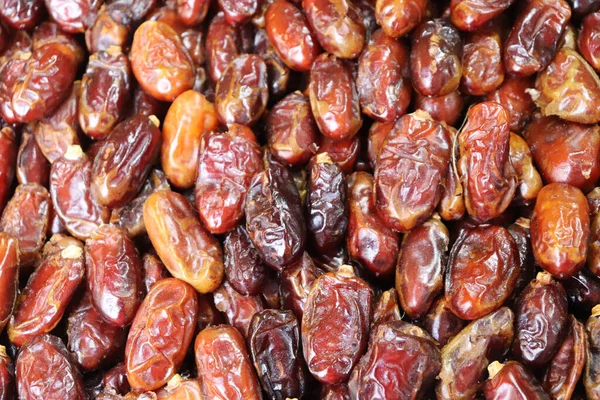 Dükkanda bir yığın hurma meyvesi. Meyve arka planlarını tarihler