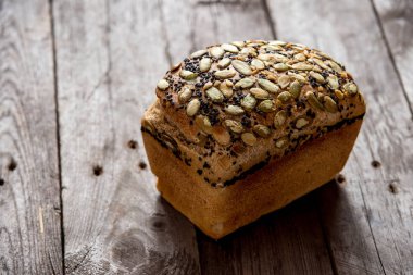 Eski ahşap zemin üzerine taze pişmiş sağlıklı ekmek. Kepekli ekmek.